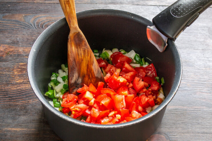 Preparing Fresh Tomatoes for a Homemade Sauce Peeled fresh tomatoes being diced into small cubes on a cutting board.
