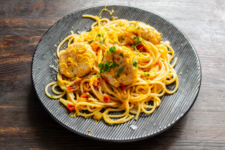 Serving the Perfect Plate of Spaghetti and Meatballs A serving of spaghetti and meatballs being plated, with extra sauce poured on top.