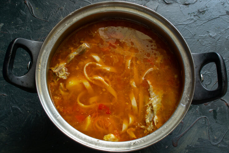 Finishing the soup by adding the flavorful vegetable base The sautéed vegetable base being added to the soup pot.