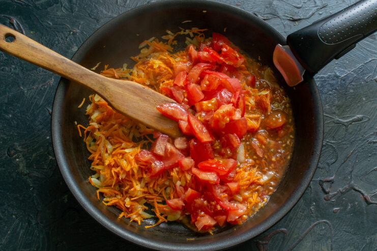 Dicing fresh, peeled tomatoes for a rich vegetable base Fresh tomatoes, peeled and diced, ready to be added to the soup base.