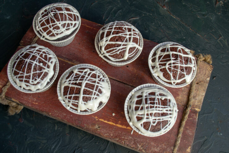 Decorating the Cooled Brownies with Melted Chocolate Drizzling melted white chocolate over the tops of the cooled beetroot brownies.