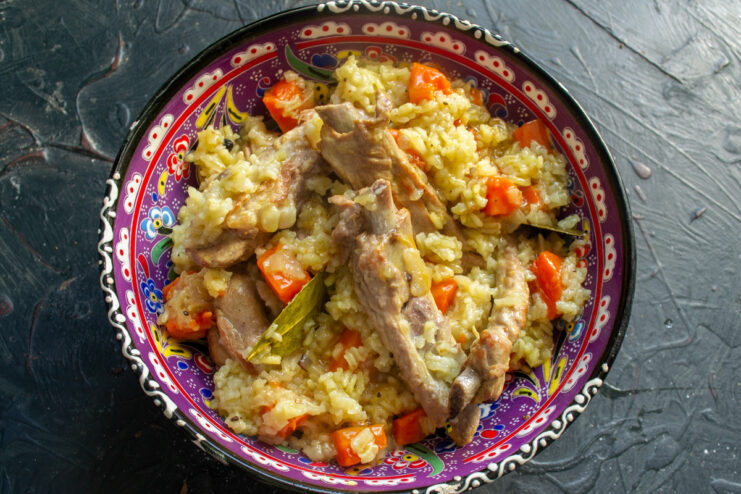 Serving the Finished Pork Ribs and Rice A large serving dish piled high with golden rice and tender pork ribs, ready for the table.