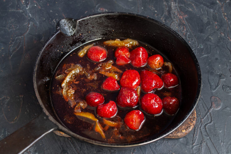 Simmering the Strawberry Sauce The strawberry sauce bubbling in a saucepan on the stove.