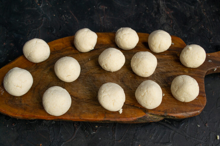 How to Shape Syrniki Hands shaping the ricotta dough into a small, flattened pancake.