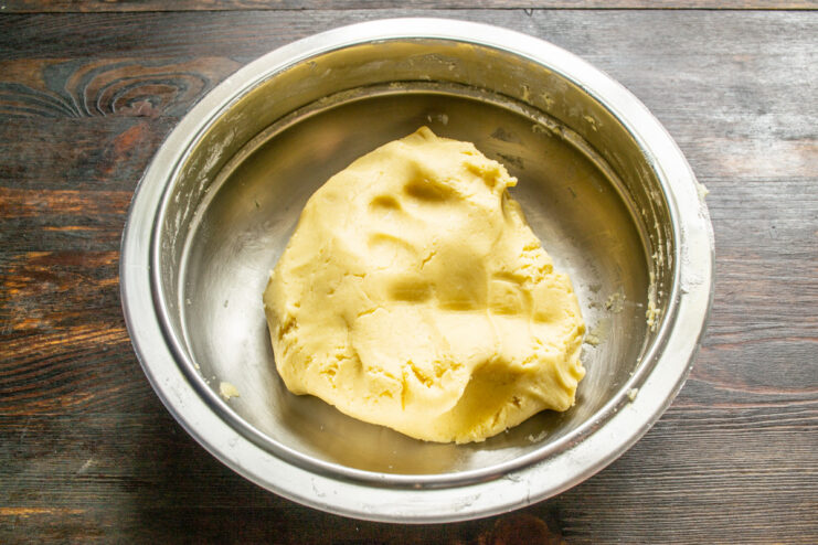 Kneading the Shortcrust Pastry Dough A hand quickly kneading the shortcrust pastry dough into a smooth ball.