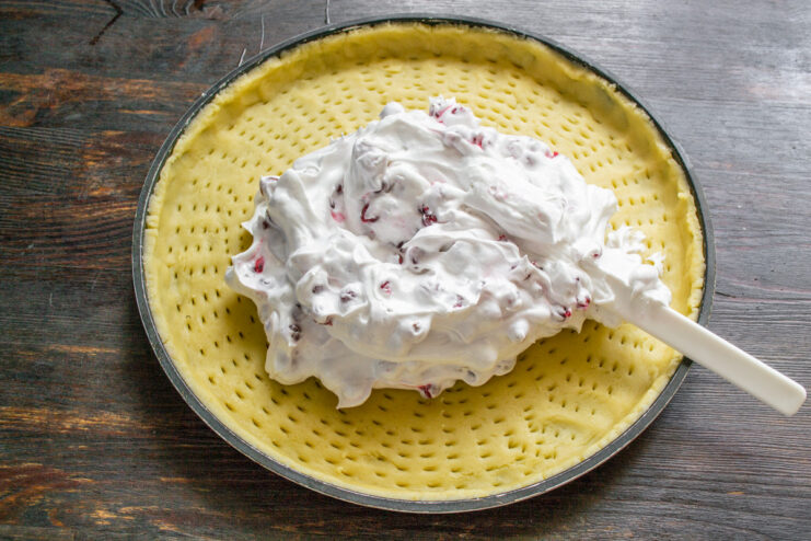 Combining Meringue and Redcurrants A bowl showing the final redcurrant meringue filling, gently mixed together.