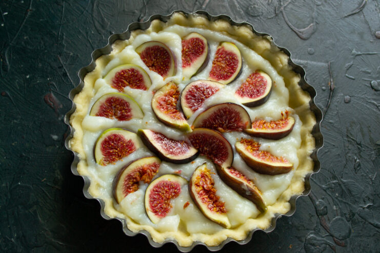 Preparing Fresh Figs for the Tart Topping Fresh figs being sliced on a cutting board.