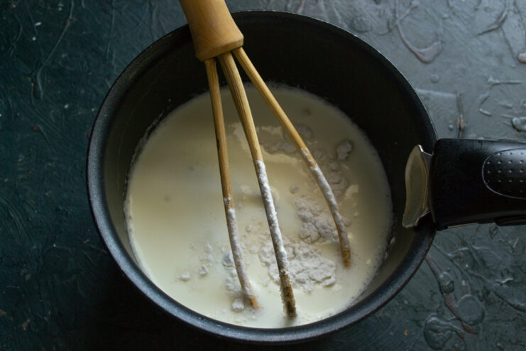 Using Potato Starch to Thicken the Custard Potato starch being added to the cream and egg mixture in a saucepan.