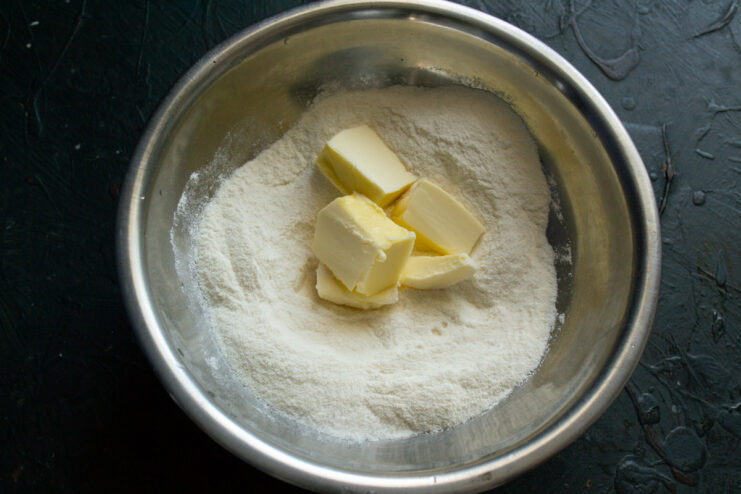 Cold Butter is Key for Flaky Pastry Cubes of cold butter being added to the flour mixture in a bowl.