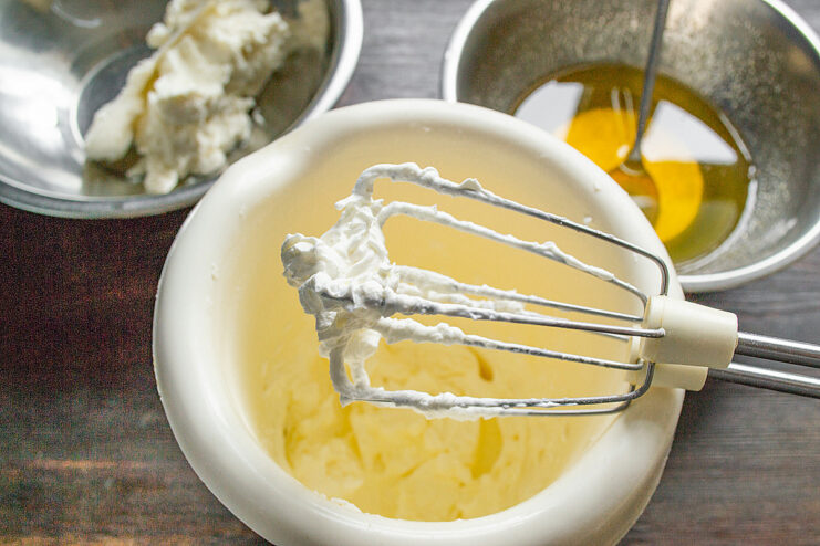 How to whip heavy cream to stiff peaks A mixer whisking heavy cream in a bowl, forming stiff peaks for the dessert.