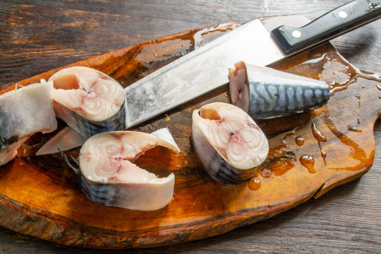 Cutting Mackerel into Steaks Cleaned mackerel cut into thick steaks on a cutting board.
