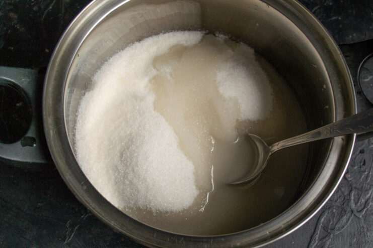 Sugar and water being combined in a saucepan to start the jam syrup.