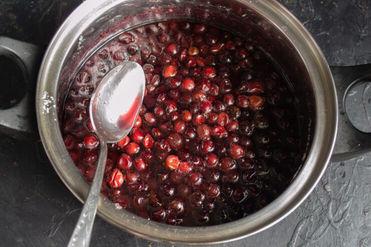 Close-up of gooseberry jam after the second boil, showing translucent berries.