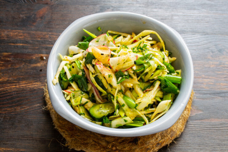 Plating the finished spring salad Plating the finished spring green onion salad in a serving bowl.