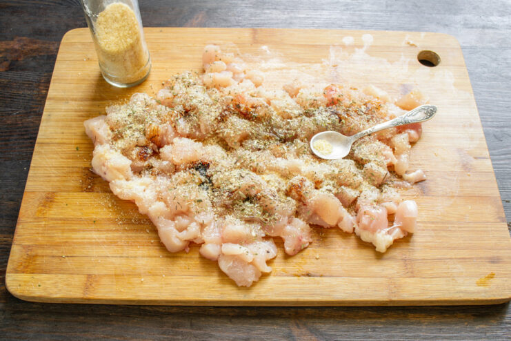 Step 4: Adding Gelatin Powder to Bind the Ham Powdered gelatin being sprinkled over the seasoned chicken cubes.