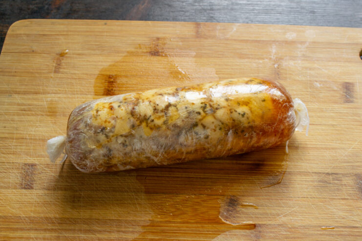 Step 7: Boiling the Chicken Ham Log The plastic-wrapped chicken ham log simmering in a pot of water.