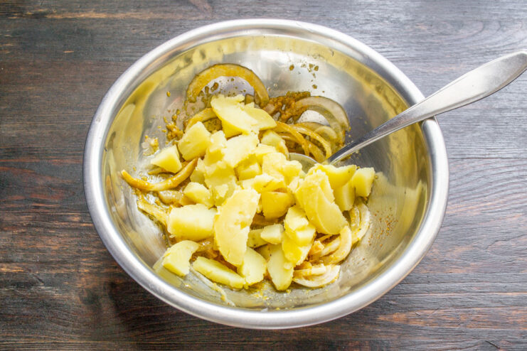 Dicing Boiled Potatoes for the Salad Diced boiled potatoes in a bowl, ready to be added to the vinegret salad.