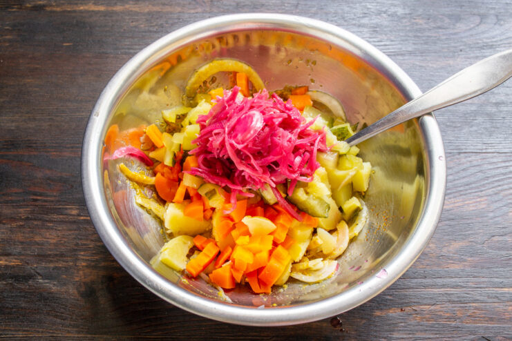 Adding Sauerkraut for Flavor and Crunch Adding a portion of sauerkraut to the bowl of chopped vegetables for the vinegret salad.