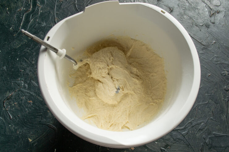 Step 4: Kneading the dough with a stand mixer. A stand mixer with a dough hook attachment kneading the Vitushka dough in a bowl.