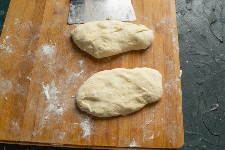 Step 7: Dividing the dough into equal portions. The proofed dough on a floured surface, divided into six equal pieces.