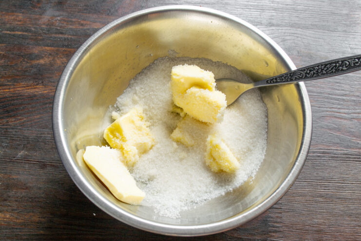Creaming butter and sugar together for the apple pie batter A bowl with softened butter and sugar being mixed.