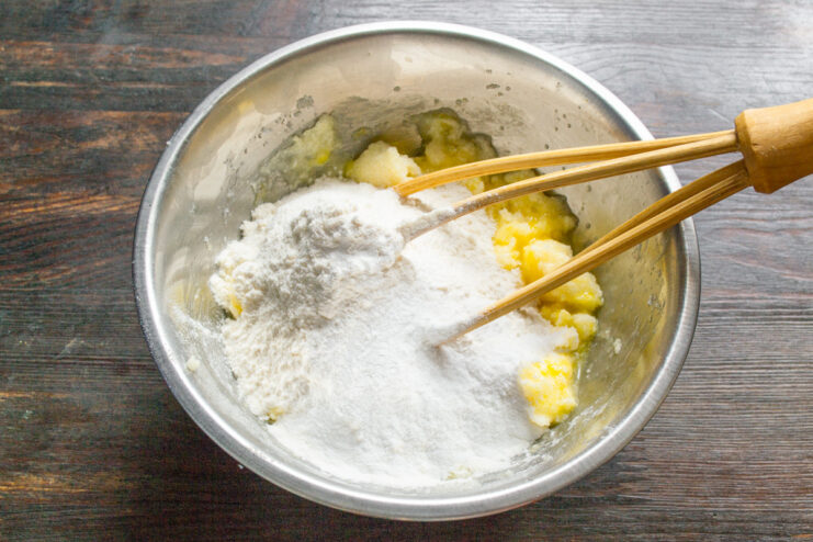 Combining dry ingredients like flour and baking powder for the pie Dry ingredients, including flour, being added to the wet mixture in a bowl.