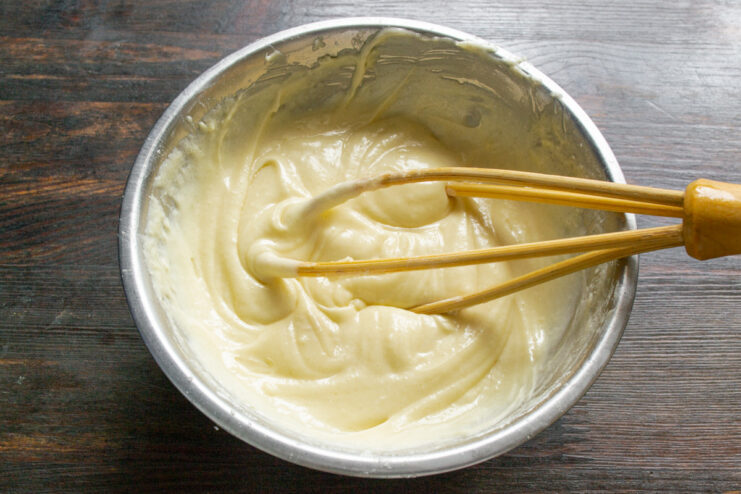 Whisking the apple pie batter until smooth A smooth, cream-like batter for the apple pie in a bowl.