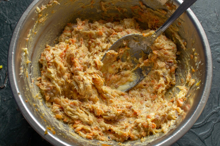 Mixing the ingredients for the herring pâté until smooth A spoon mixing herring, carrot, and butter in a bowl to create a smooth pâté.