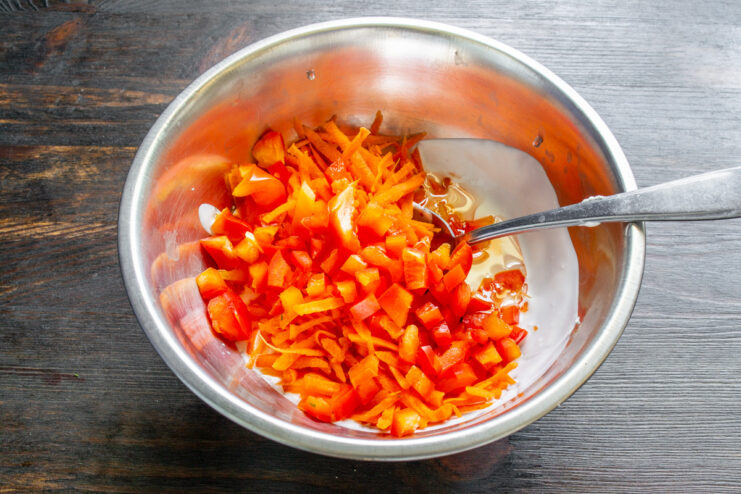 Dicing Red Bell Pepper for a Pop of Color and Flavor A hand dicing red bell pepper on a cutting board.