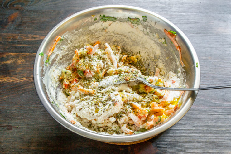 Enhancing Flavor with Herbes de Provence or Fresh Herbs A pinch of dried herbs, like Herbes de Provence, being added to the muffin batter.