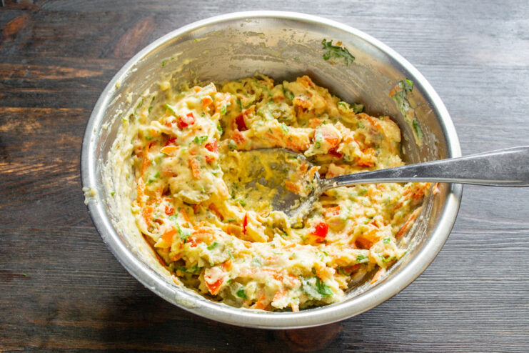 Mixing the Savory Muffin Batter Until Well Combined The final savory muffin batter being mixed thoroughly in a white bowl.