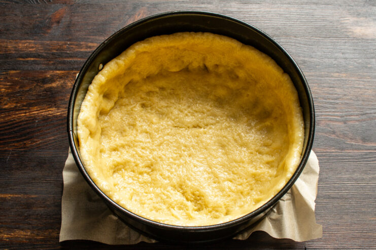 Placing the Dough in the Pan Pressing the rolled-out dough into the springform pan, forming a crust with high sides.