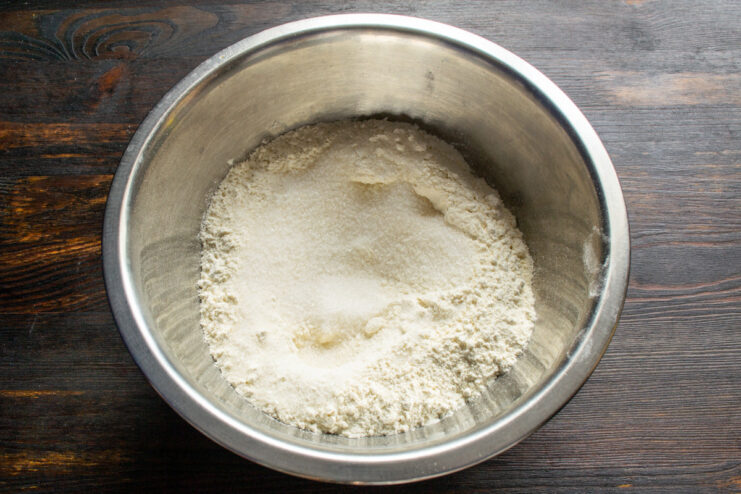 Combining Dry Ingredients for the Pie Crust A bowl with all-purpose flour and baking powder being mixed for the pie dough.
