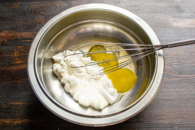 Preparing the Pumpkin and Sour Cream Filling A bowl containing eggs, smetana (sour cream), and sugar for the pie filling.