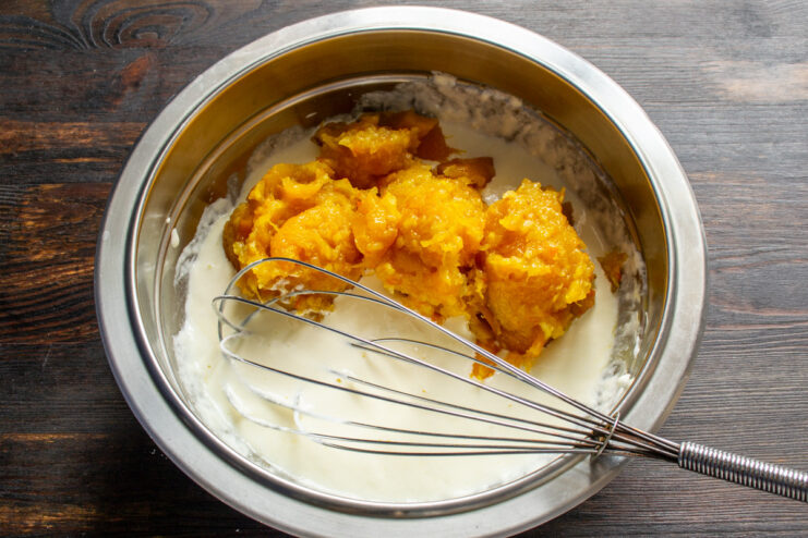 Adding Pumpkin Puree to the Filling Adding a spoonful of bright orange pumpkin puree to the sour cream and egg mixture.