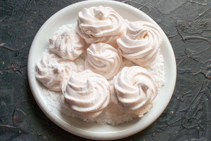 Assembling the Zefir and Dusting with Powdered Sugar Assembling zefir halves and placing them in a bowl of powdered sugar.