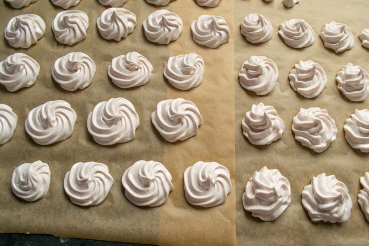 Piping the Perfect Zefir Halves to Set Piping swirls of pink zefir mixture onto parchment paper using a piping bag.