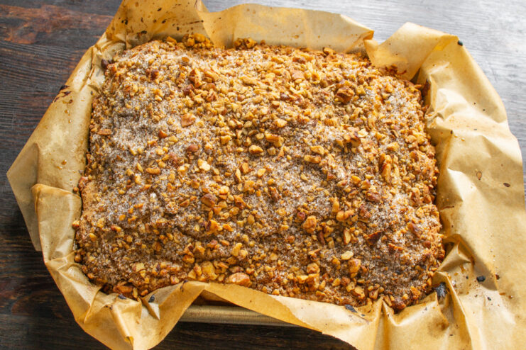 Removing the Freshly Baked Cake from the Pan Lifting the freshly baked orange cake out of the baking pan using the parchment paper.