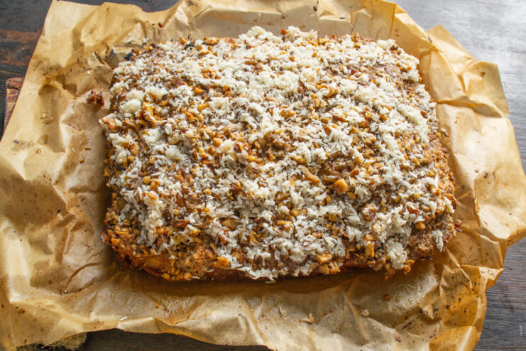 Finishing the Cake with a Warm Glaze Pouring the warm, creamy coconut glaze over the freshly baked orange and walnut cake.