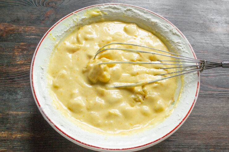 Flavoring the Batter with Vanilla Mixing vanilla extract into the orange cake batter before letting it rest.