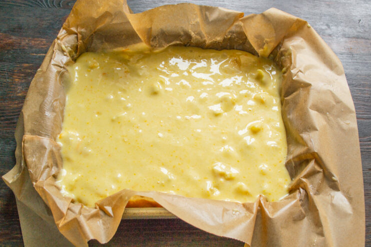 Pouring the Batter into the Baking Pan Pouring the finished orange cake batter into a parchment-lined baking pan.