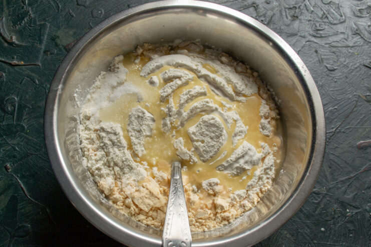 Combining Milk and Flour for the Blinchiki Batter Adding flour and milk to a bowl to prepare the crepe batter.