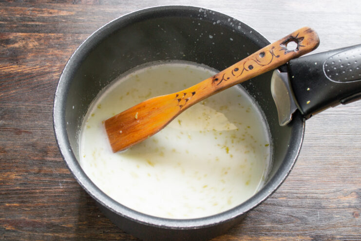 A saucepan on a stove with a milk and sugar mixture coming to a boil.