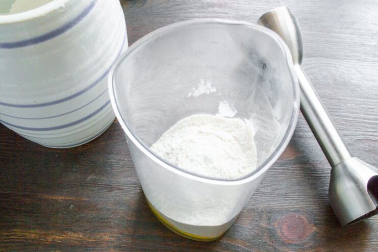 Adding Flour to the Bliny Batter All-purpose wheat flour being added to the blender cup with the egg.