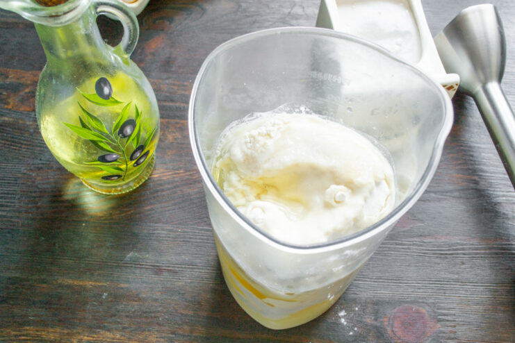 Adding Vegetable Oil for a Smooth Bliny Batter Pouring vegetable oil into the blender cup to complete the bliny batter mixture.