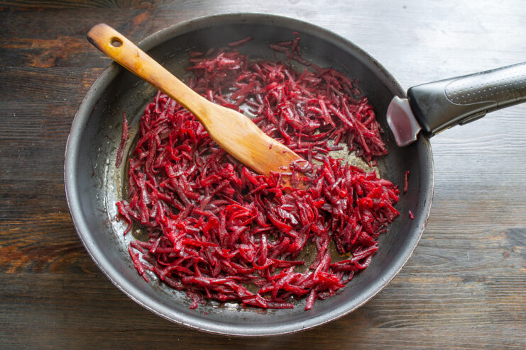 How to properly sauté beets for a rich borscht flavor Sautéing grated beets in a pan, stirring with a spatula.