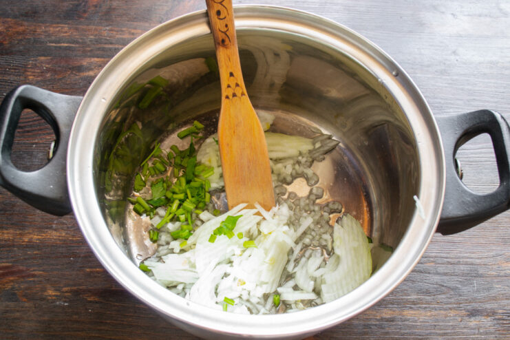 Cooking the onions and celery until soft and translucent Diced onions and celery being sautéed in a pot.