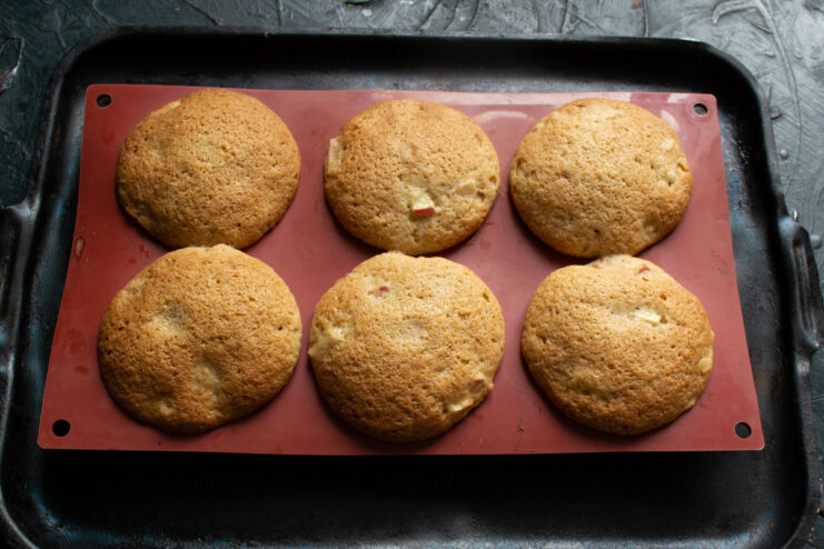 Baking the apple buns until golden brown and cooked through. A silicone mold with apple buns baking inside a hot oven.