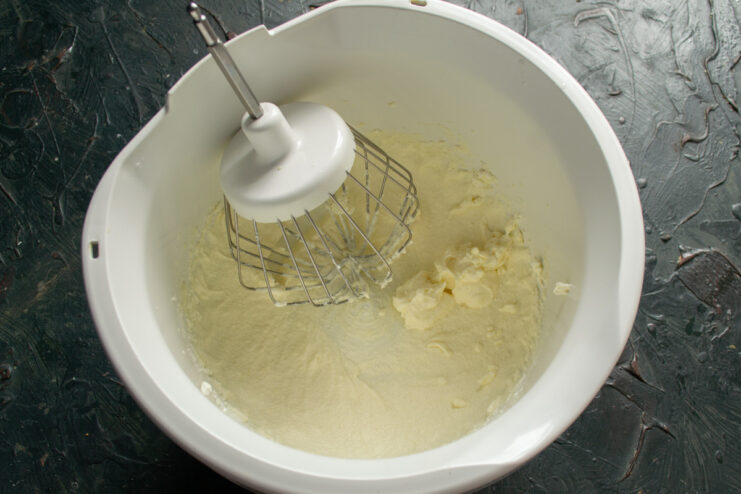 Preparing the whipped cream filling using cold heavy cream. Pouring cold heavy cream into the metal bowl of a stand mixer.