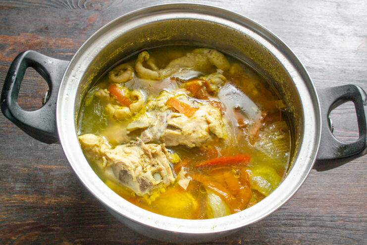 Simmering chicken broth for maximum flavor A pot of chicken broth simmering on a stove over low heat.